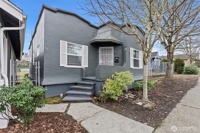 view of front facade with fence and stucco siding