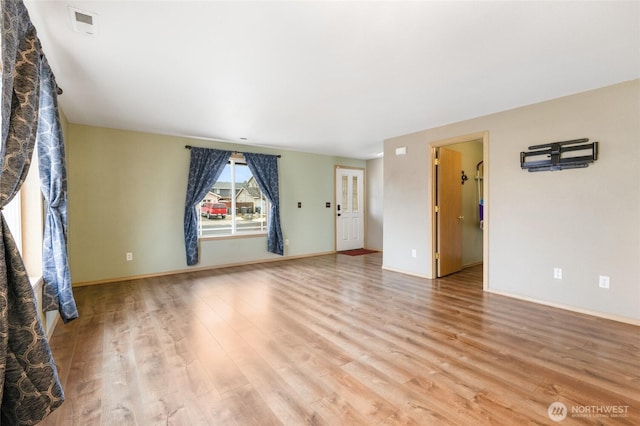 unfurnished living room with light wood-style flooring and baseboards