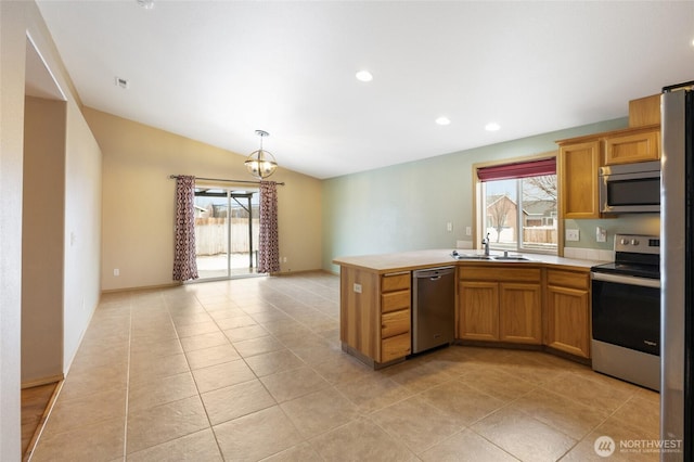 kitchen with open floor plan, stainless steel appliances, brown cabinetry, and light countertops