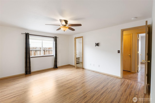 unfurnished room with a ceiling fan, baseboards, and light wood finished floors