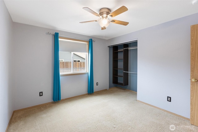 unfurnished bedroom with a closet, carpet, a ceiling fan, and baseboards