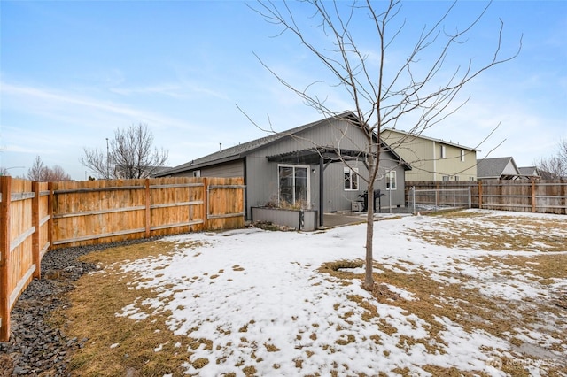 snow covered property with a fenced backyard