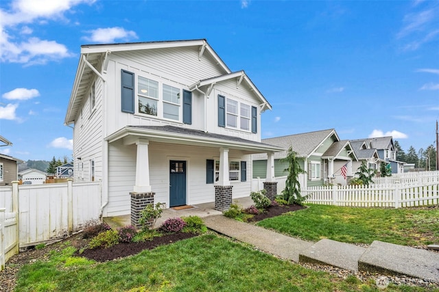 view of front of home featuring a porch, board and batten siding, a front lawn, and fence