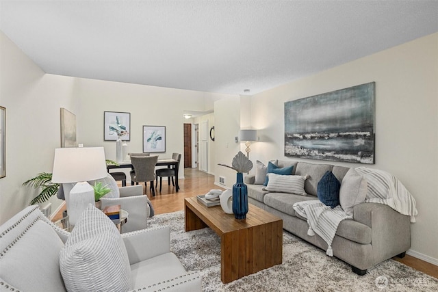 living area with light wood-style flooring and baseboards