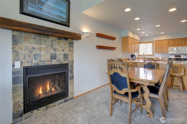 dining space featuring recessed lighting, a fireplace, baseboards, and light colored carpet