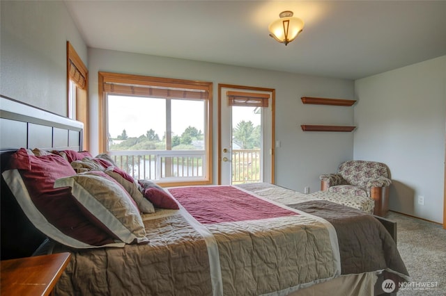 carpeted bedroom featuring access to exterior, multiple windows, and a water view