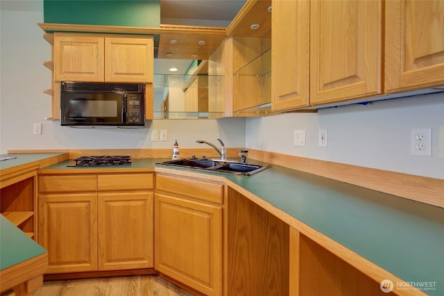 kitchen featuring open shelves, light countertops, a sink, gas cooktop, and black microwave