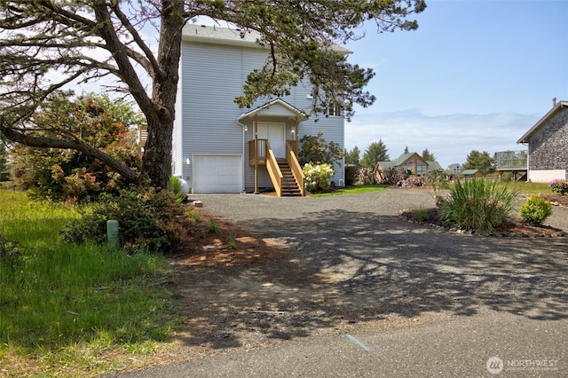 view of front of property with an attached garage and dirt driveway