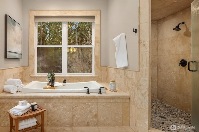 bathroom with a garden tub and tiled shower