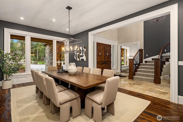 dining space with recessed lighting, stairs, a notable chandelier, and wood finished floors