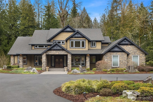 craftsman house with aphalt driveway and a shingled roof