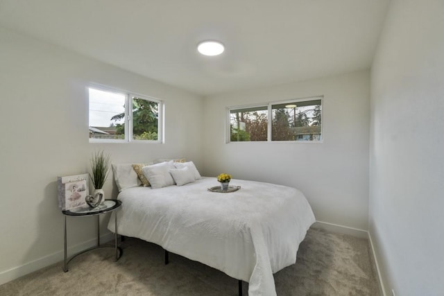 bedroom with light carpet and baseboards