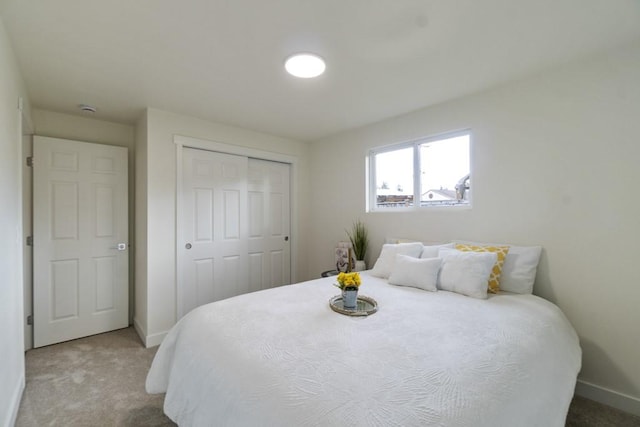 carpeted bedroom featuring a closet and baseboards