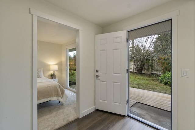 foyer entrance with dark wood-style floors and baseboards