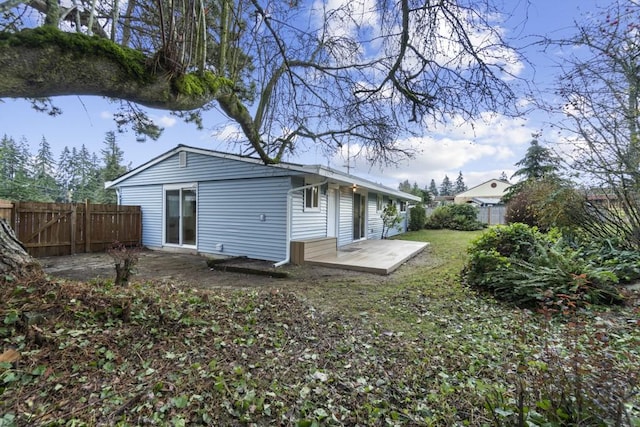 rear view of house with a patio and fence