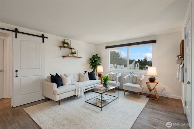 living area featuring dark wood-style floors, baseboards, and a barn door