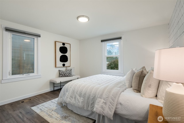 bedroom featuring dark wood-style floors, visible vents, and baseboards