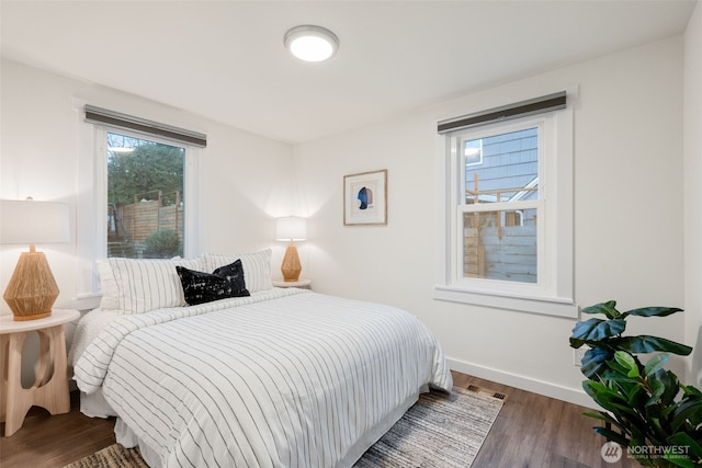 bedroom with dark wood-type flooring, visible vents, and baseboards