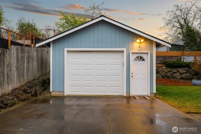 detached garage with aphalt driveway and fence