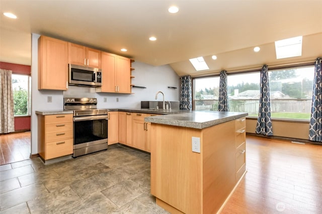 kitchen featuring appliances with stainless steel finishes, light brown cabinetry, a peninsula, and open shelves