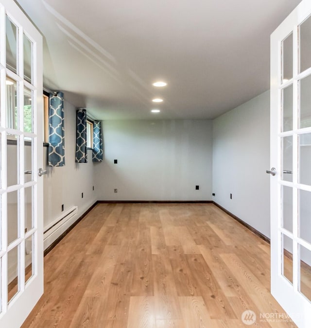 spare room with a baseboard radiator, recessed lighting, baseboards, french doors, and light wood finished floors