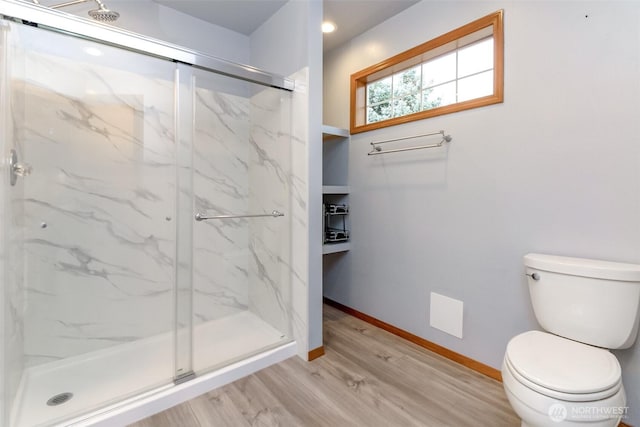 full bath featuring wood finished floors, a marble finish shower, toilet, and baseboards