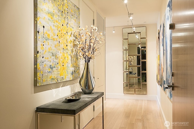 hallway featuring light wood-style floors and baseboards