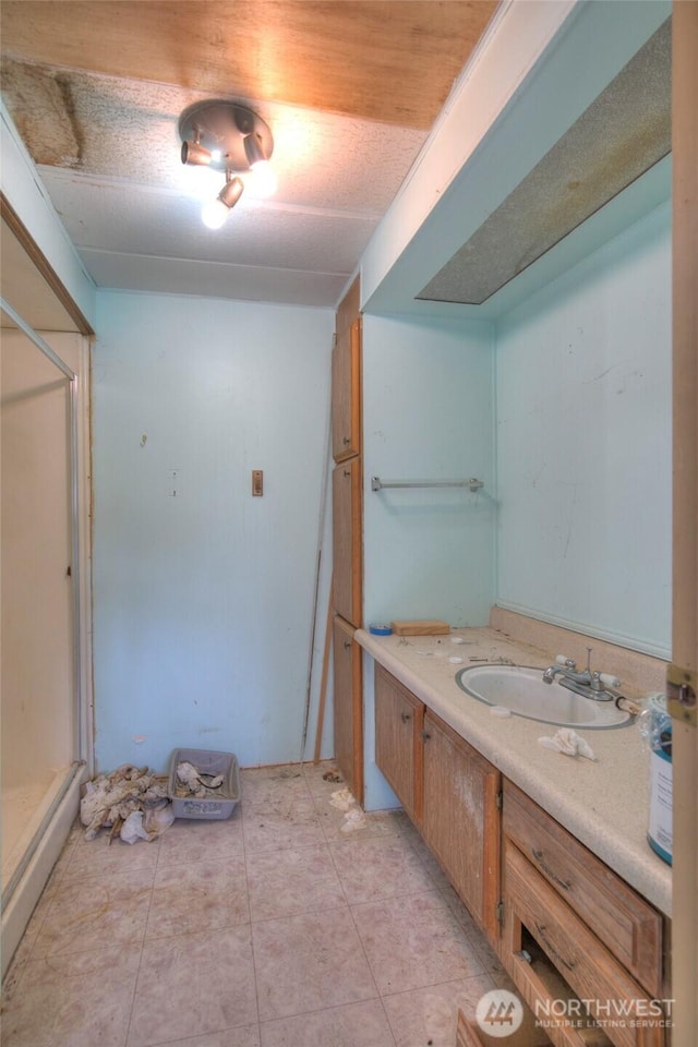 full bath featuring a stall shower, vanity, and tile patterned floors