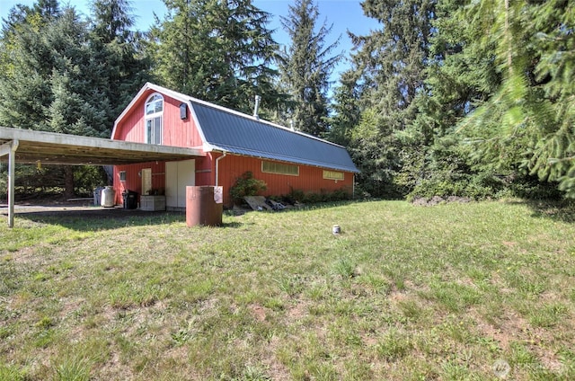 view of side of property featuring metal roof, a yard, an outdoor structure, and a gambrel roof