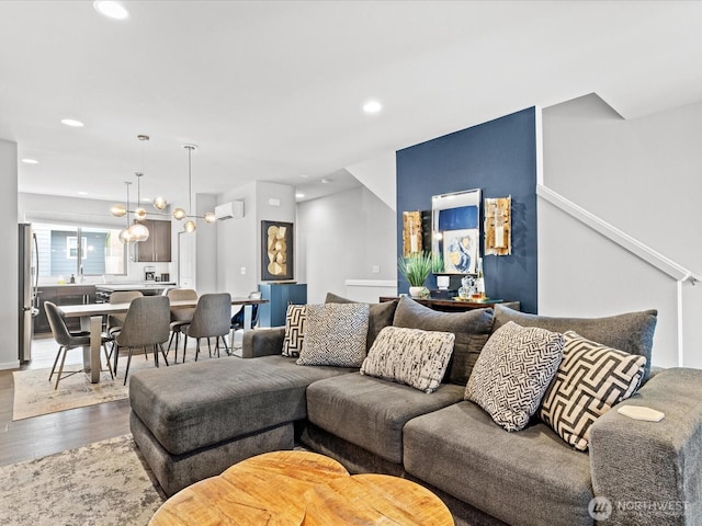 living room featuring dark wood-style floors, a wall unit AC, and recessed lighting