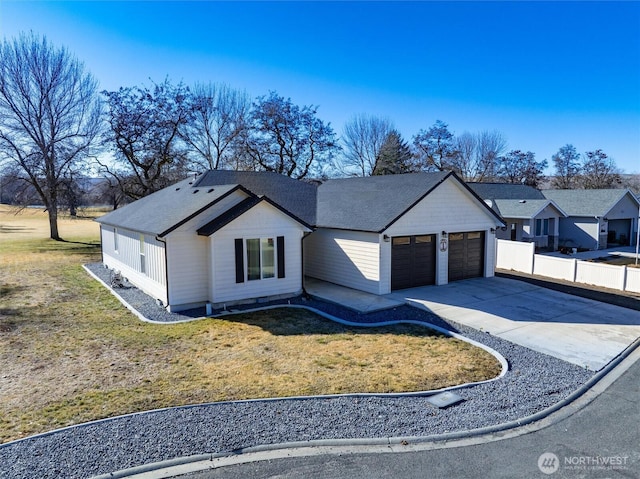 modern inspired farmhouse with a garage, concrete driveway, a front yard, and fence