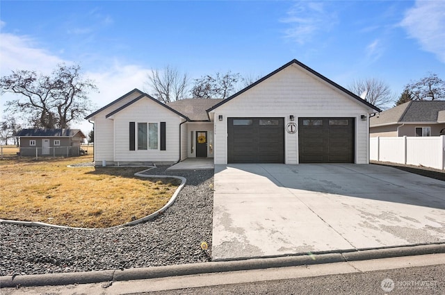 single story home with concrete driveway, an attached garage, and fence