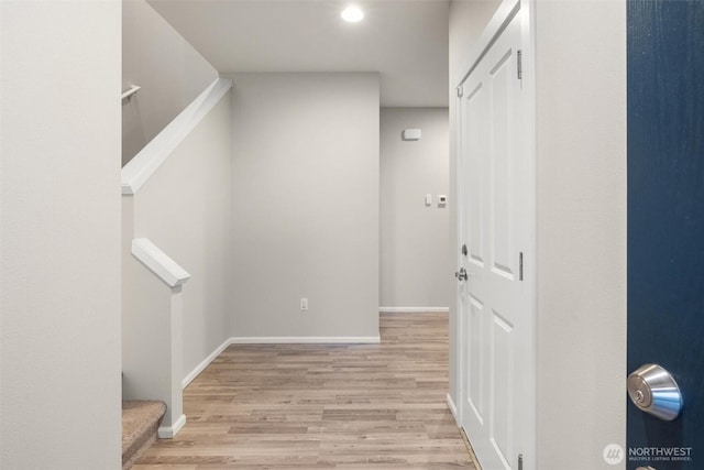 hall featuring stairs, baseboards, and wood finished floors