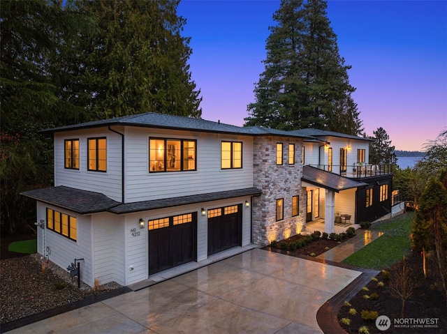 view of front of property with stone siding, driveway, and a garage