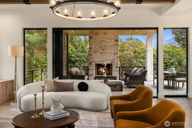 interior space with a healthy amount of sunlight, an outdoor stone fireplace, and a notable chandelier