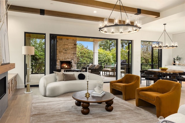 sitting room featuring a stone fireplace, recessed lighting, a notable chandelier, beam ceiling, and light wood finished floors