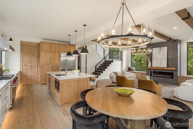 dining area with beam ceiling, recessed lighting, light wood-style flooring, stairway, and a high end fireplace