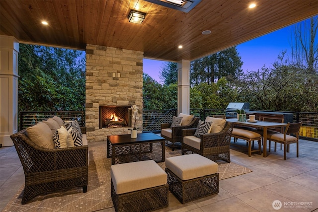 view of patio / terrace featuring an outdoor living space with a fireplace, an outdoor kitchen, and a grill