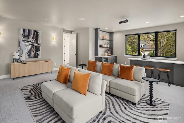 living area featuring light carpet, baseboards, a dry bar, and recessed lighting