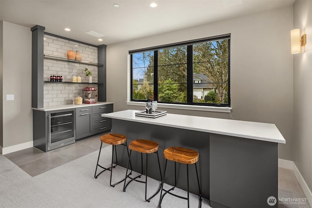 bar featuring tasteful backsplash, baseboards, wine cooler, a bar, and recessed lighting