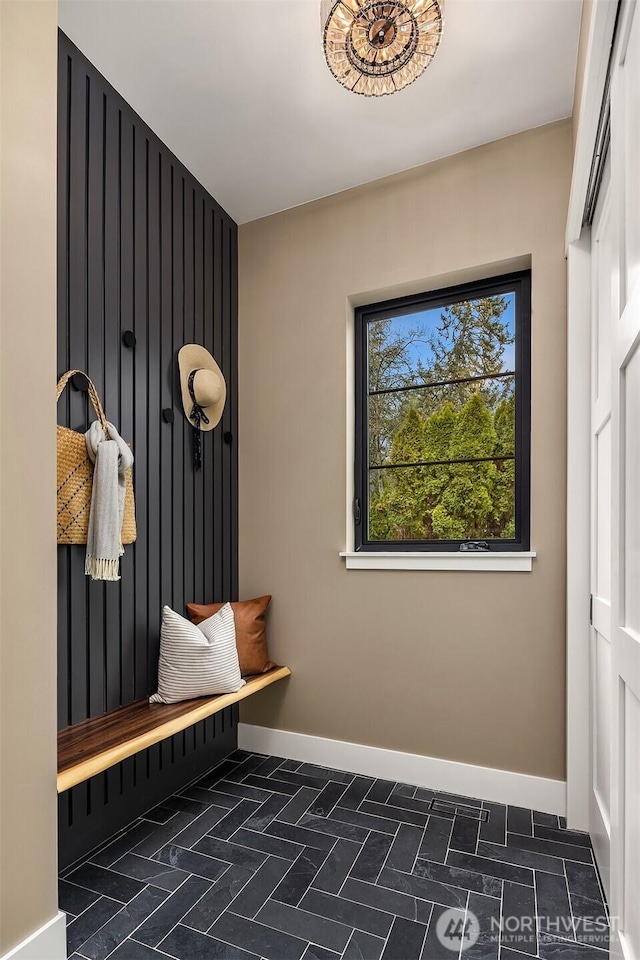 mudroom with brick floor and baseboards