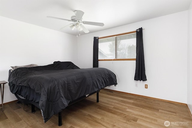 bedroom featuring ceiling fan, baseboards, and light wood-style floors