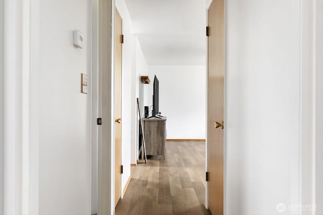 hall with wood finished floors and baseboards