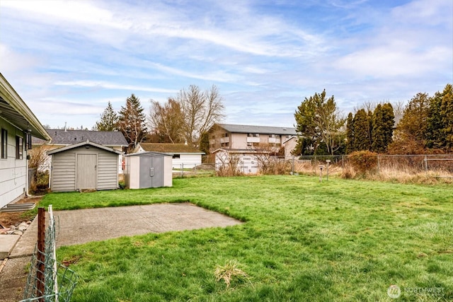 view of yard with an outbuilding, fence, and a storage unit