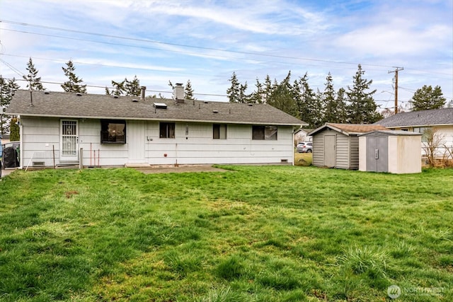 back of house featuring a storage unit, an outbuilding, and a yard