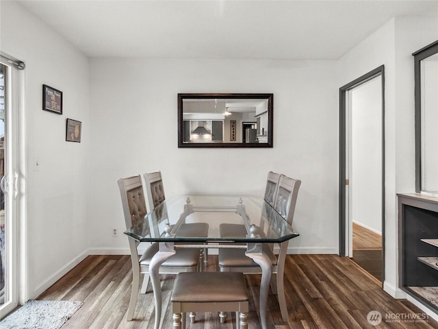 dining area with dark wood-style floors and baseboards