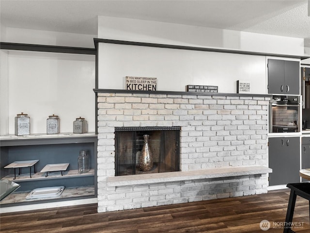 room details featuring oven, a textured ceiling, and wood finished floors