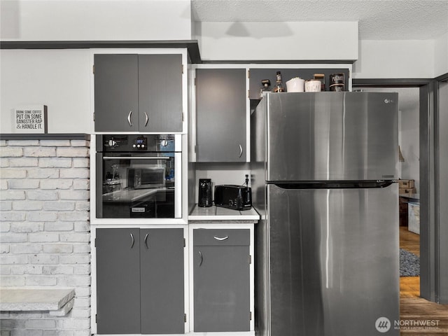 kitchen with appliances with stainless steel finishes, light countertops, and a textured ceiling