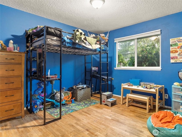 bedroom featuring a textured ceiling and light wood-type flooring