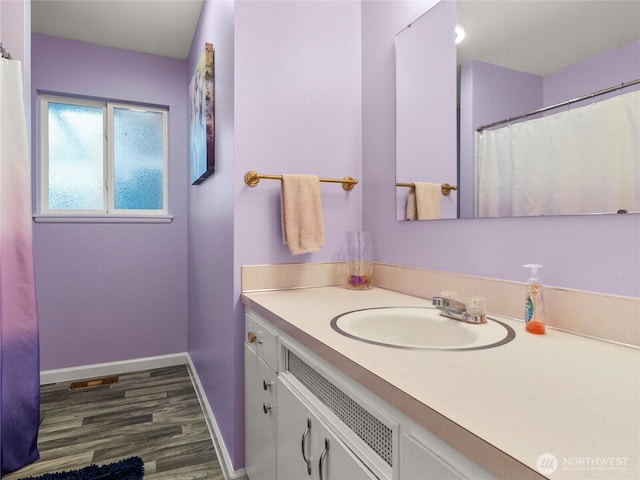 full bath with vanity, baseboards, and wood finished floors